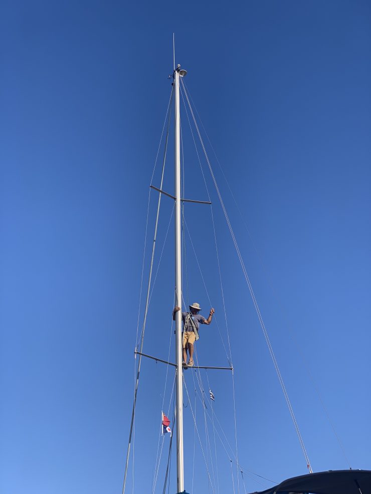 Man climbing mast on yacht